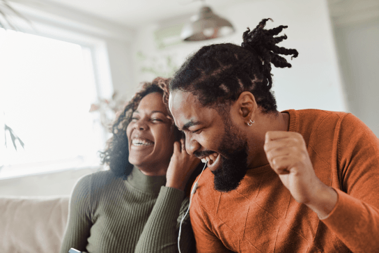 two people laughing on sofa