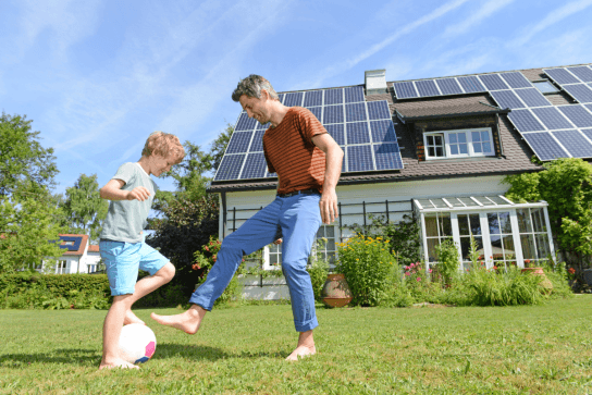family with solar panels on home