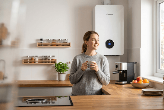Person standing in a kitchen setting with a boiler visible in the background