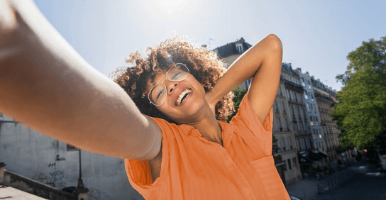 Happy woman on balcony in orange tee