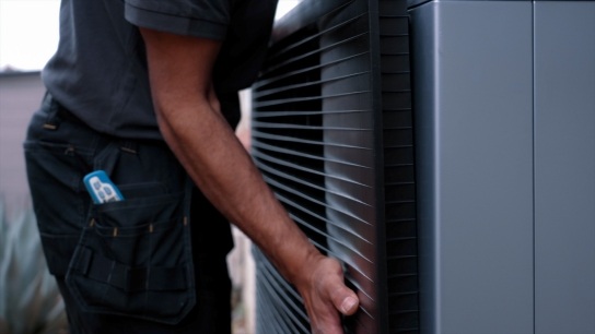 CB Heating installer carrying an air source heat pump