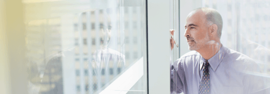 Smiling man peering out of window