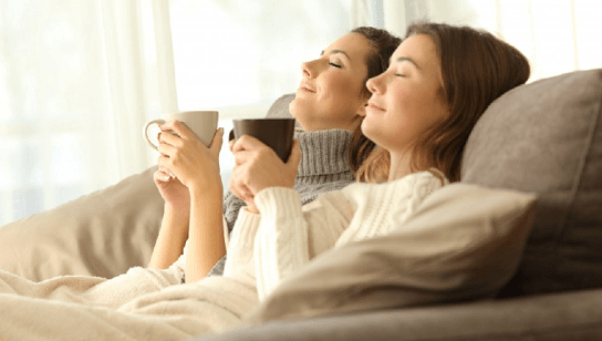 Two women relax with a warm drink