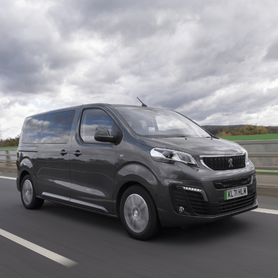 Peugeot e-Traveller in black driving down road