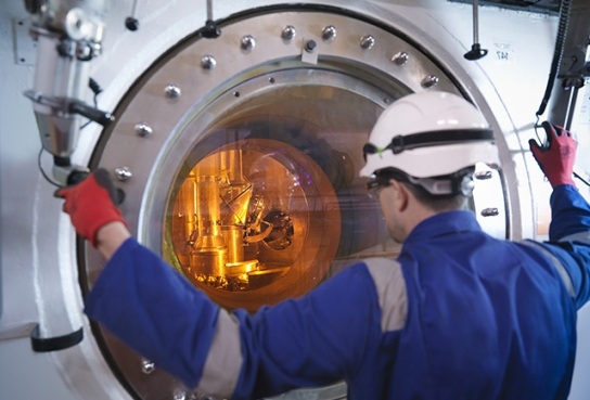 Engineer looking through a restricted porthole viewing pane