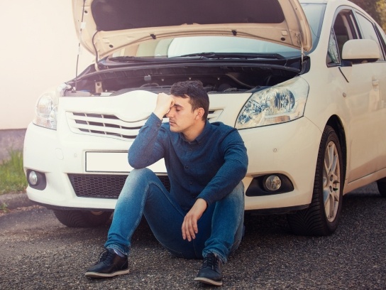 Man with white car broken down requiring maintenance