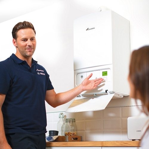 gas boiler repair engineer with customer in home explaining the problem with a boiler