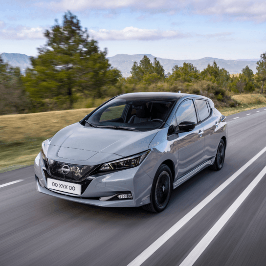Nissan LEAF in grey driving down road 