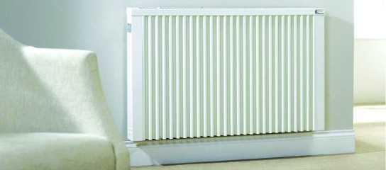 Electric radiator on wall next to a chair
