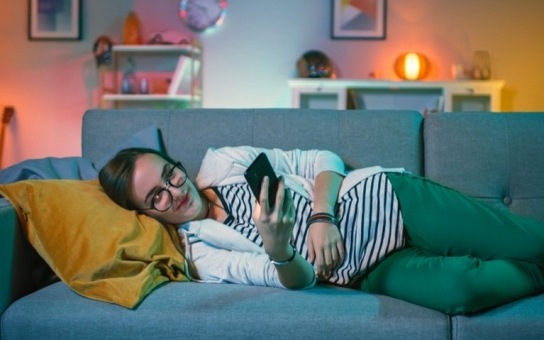 Woman relaxing on a sofa using her smartphone