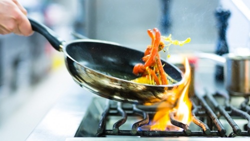Frying pan over a flame in a restaurant kitchen