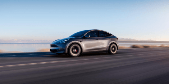 Tesla Model Y in silver driving on the road 