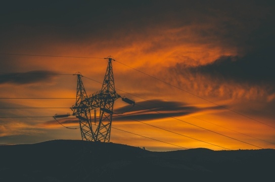 Electricity pylons against a sunset